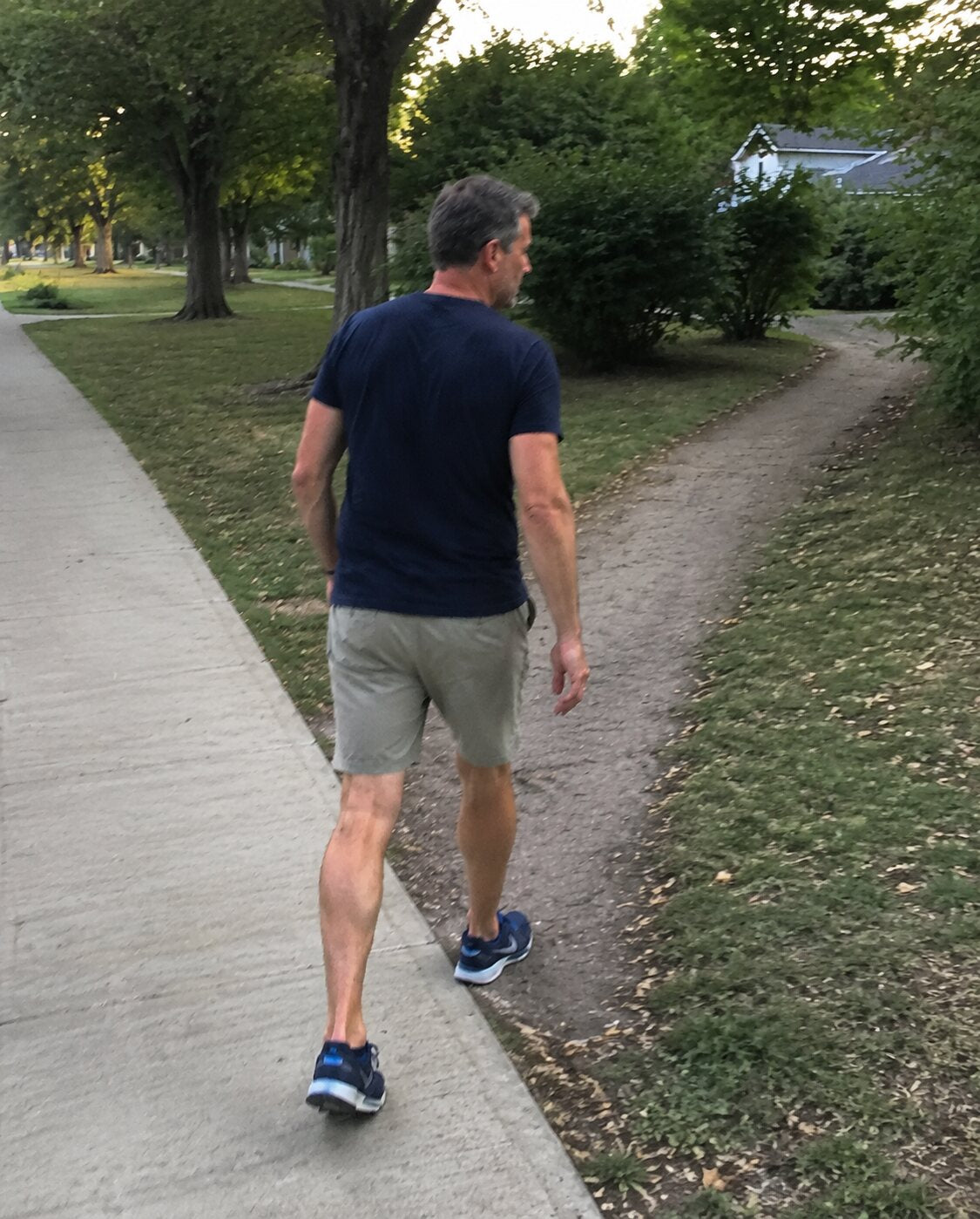 A man taking an afternoon walk through his neighbourhood